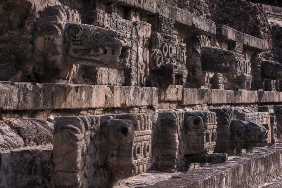Carved stone serpent heads projecting from an ancient temple facade at Teotihuacan