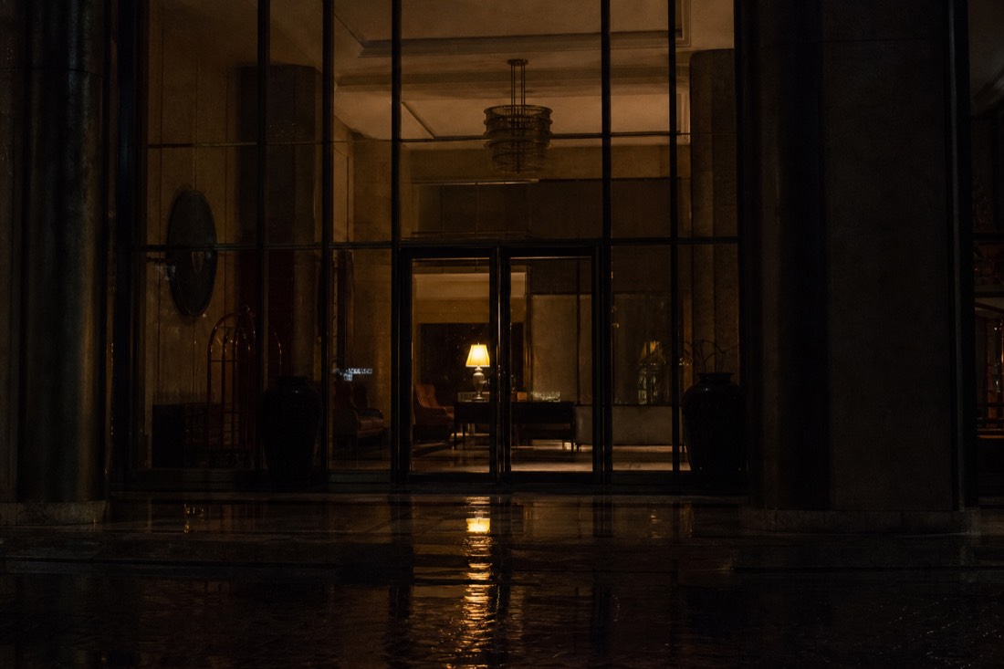 A dark Mexico City hotel entrance seen from the street before dawn